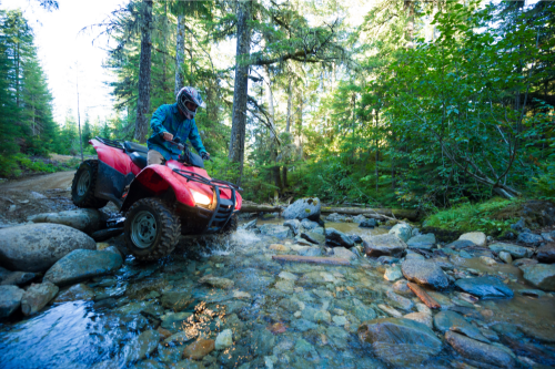 Person Riding ATV Across River
