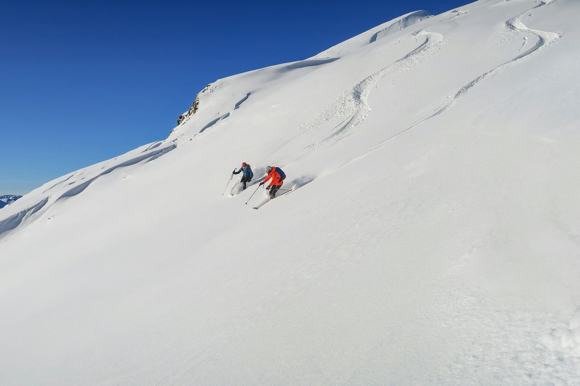 Two People Skiing Down Slope